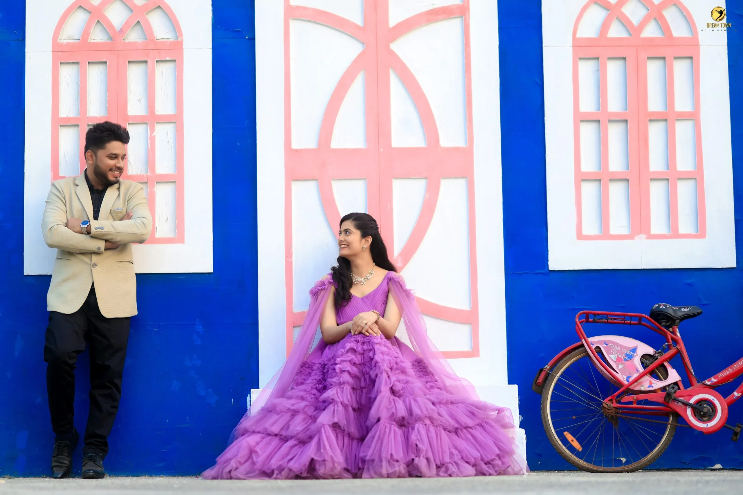 Bride in lehenga and groom in sherwani posing at Dream Town Film Studio