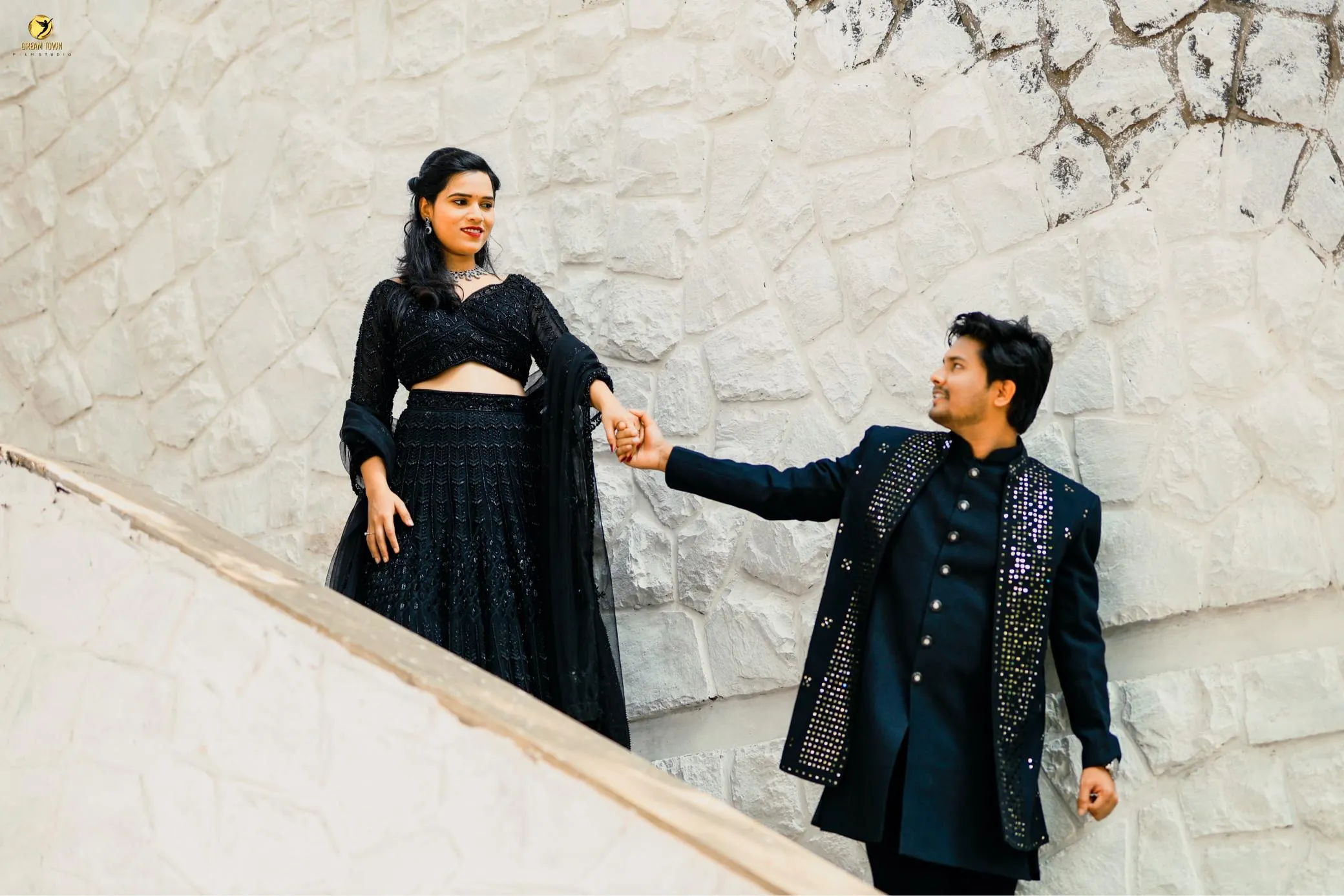 Bride in lehenga and groom in sherwani posing at Dream Town Film Studio
